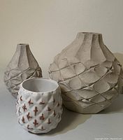 Front view of all three vases grouped together showing size and design differences.
