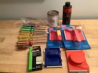 Lot of screwdrivers with yellow and green handles and clear yellow handles, paint sample can, painting tools including paint edger and paint tray.