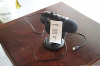 Blue Yeti USB microphone mounted on adjustable round metal stand with USB cable visible on wood surface.