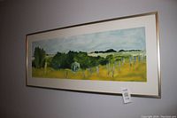 Frontal view of panoramic landscape oil painting in gold and copper wood frame.