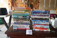 Image showing a stack of assorted kids DVDs arranged on a table, titles visible include Frozen Snowman, Happy Feet, Brother Bear, etc.