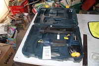 Mastercraft air-powered finish nailer in a blue carrying case, on a white table with other items in background.