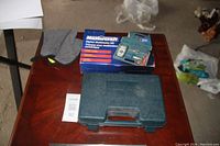 Photo of the closed hard carrying case and the product box featuring the Mastercraft digital multimeter kit.