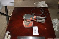 Ridgid random orbital sander showing general top view with dust collection bag and power cord on wooden surface