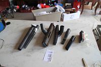 Photo of the vacuum heads and connectors set arranged on a kitchen table with multiple black plastic pieces.
