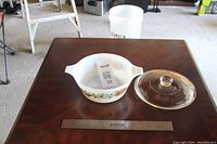 Top down photo of casserole dish and lid with ruler for scale