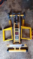 Full view of yellow Cub Cadet mower lift assembly with brackets extended and handle stowed