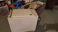 Photo of vintage storage hamper with hinged lid closed, showing woven texture and handles