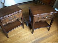 Pair of wooden night tables, 23x15x26 inches, with drawer and lower shelf on hardwood floor.