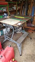 Front angled view of Black & Decker Workmate deluxe workbench in a utility shed with tools and other items in background.