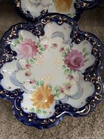 Close-up photo showing a single Royal Nippon berry bowl with cobalt blue edges, gold scroll detailing, and floral hand-painted decoration.
