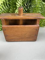 Front view of the wooden butter mould press showing the handle and body