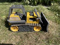 Side view of the vintage Tonka bulldozer toy showing rubber tracks and metal blade.