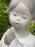 Close-up of the angel's face showing hand-painted eyes, eyebrows, and lips with delicate expression.