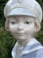Close-up of the figurine's face showing detailed features and glossy porcelain finish.
