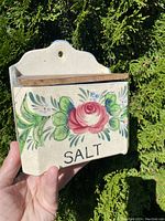 Front view of the hand painted vintage salt box with floral designs and wood lid