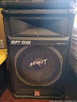 Front view of one Peavey SP 5G speaker showing the woofer, logo, and speaker grille.
