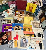 Photo showing a collection of assorted vinyl LP records covers gathered together on a flat surface. Covers feature classical music and opera artists with portraits, titles and artwork visible.