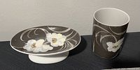 Photo of ceramic soap dish and matching cup with floral and swirl patterns.