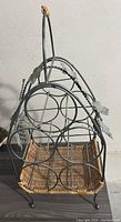 Front side view of the table top wine rack showing circular bottle holders and wicker bottom shelf.