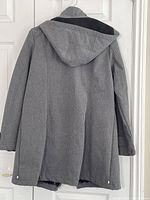 Back view of the grey women's coat showing attached hood and seam details.