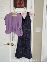 Full view of dress and shrug hanging on door showing overall appearance and length.