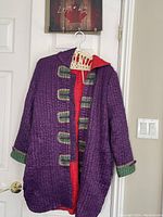 Front view of the purple Yazhouli coat showing toggle closures, hood, and red lining.