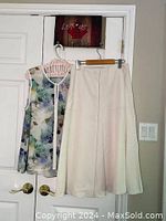 White A-line maxi skirt and sleeveless floral top hanging on door