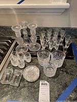 Photo taken showing full lot arrangement on countertop with candlesticks, cordial glasses, rocks glasses, coasters, and ashtrays visible.