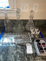 Full lot with three decanters, tray, four glasses, and Houdini wine preserver kit on counter