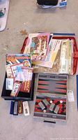 Full overview of lot showing harmonicas, puzzle folders, magazines, and game board case