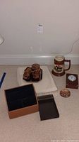 General view of all items in lot including Limoges stein, desk clock, paperweight, glass trays, jars, desk organizer, and white throw.