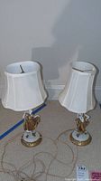 Full view of both porcelain boudoir lamps with white fabric shades, showing overall structure and design.