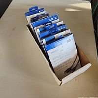 Box containing multiple Insignia cables and one adapter in retail packaging.