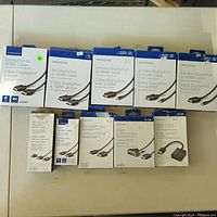 Photo showing all 9 items in original packaging arranged on a table, each identifiable through box labels and cable ends shown.