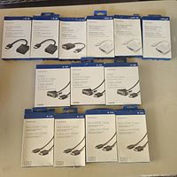 Full lot of Insignia cables and adapters in their retail packaging arranged in rows showing all included models.