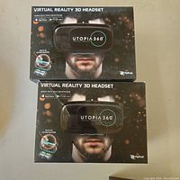 Two boxed Utopia 360 virtual reality 3D headsets for smartphones shown from the front of the boxes.