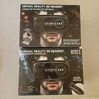 Photo of two Utopia 360 Virtual Reality 3D headset boxes. One box highlights the inclusion of a Bluetooth controller; the other is for a headset without the controller.