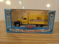 Front view of the yellow 1942 Chevrolet truck diecast model in original packaging showing branding and design details.
