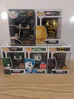 Five Funko Pop figures including Batman (Suicide Squad and Batman logos), Gold Gamora from Marvel Studios, The Joker from DC Super Heroes, and Batman from Hot Topic.