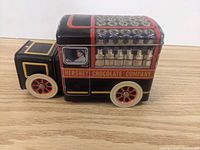 Side view of Hershey Chocolate Company tin truck with detailed painted design, driver inside cabin, and wheels.