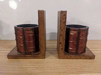 Front view of the pair of leather wrapped wooden bookends showing gold decorative details on leather and wood wear.