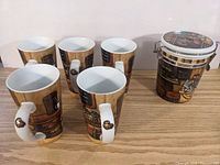 Set of five ceramic mugs and one ceramic canister with kitchen-themed design shown from side view on wood surface.