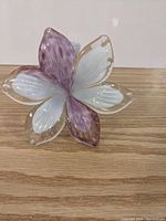 Top view of the purple and white glass flower showing six petals with blended colors.