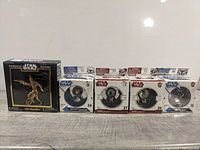 Full lot of Star Wars collectibles showing Luke Skywalker die cast keychain boxed and four Star Wars pin badges in packaging placed in a row