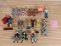 Full lot of 17 assorted character figures on wooden surface with a pink label 'Toy lot #2' visible