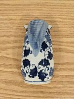 Front view of the ceramic wall plant holder with blue floral design on white background.