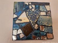 Photo of 6-inch square mosaic tile art showing blue heart and ceramic tile fragments