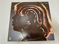Front cover of The Rolling Stones Hot Rocks 1964-1971 LP showing stylized silhouette profiles of band members with creative lighting effects.