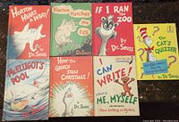 Seven vintage children's books laid out showing front covers: six Dr. Seuss titles plus one by Theo. LeSieg. Colorful, whimsical covers with classic characters.